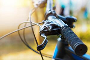 selective focus Close-up view of a bicycle handlebar and brake lever, showcasing the textured grip and cable details. photo