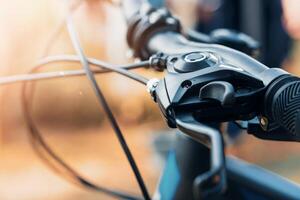 selective focus Close-up view of a bicycle handlebar and brake lever, showcasing the textured grip and cable details. photo