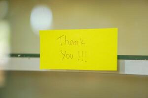 A cheerful note saying Thank You on a bright yellow sticky note, enhancing positivity in any space. photo