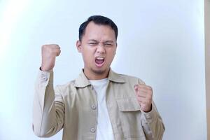 A man expressing excitement and determination with raised fists and a fierce look. photo