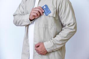 A young man in a beige jacket proudly displays his credit card photo