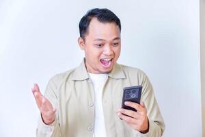 A man joyfully reacts to something exciting on his smartphone. photo