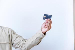 A hand holding a modern credit card with a microchip against a plain background. photo