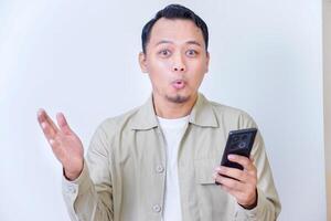A man joyfully reacts to something exciting on his smartphone. photo