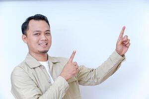 A smiling man in a beige jacket gestures with his hand, pointing at something. photo