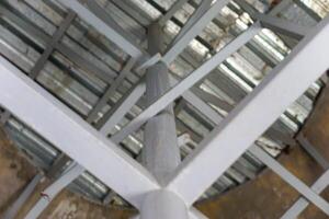 A close-up view of steel beams and roofing structure from below, showcasing design and texture. photo