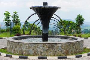 A modern fountain surrounded by greenery, creating a serene outdoor atmosphere. photo