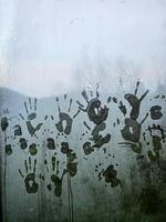 Handprints on a foggy window create a mysterious and artistic scene. photo