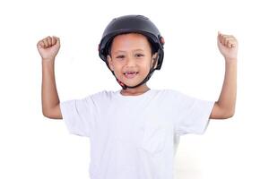 A cheerful asian child wearing a helmet, celebrating with raised fists and a bright smile. photo