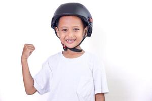 A cheerful asian child wearing a helmet, celebrating with raised fists and a bright smile. photo
