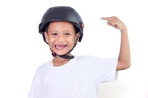 A confident asian boy wearing a helmet, pointing to his helmet with a big smile. photo