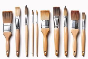 Nine paintbrushes of various sizes and shapes with wooden handles. photo