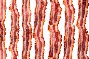 Close-up of crispy cooked bacon strips isolated on a white background. photo