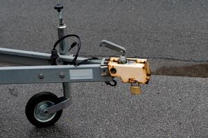 Front section of a trailer hitch on a paved surface. photo