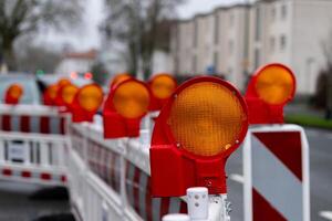 Construction barriers with warning lights in urban setting at dusk photo