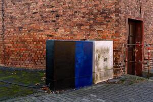 Colorful utility boxes against a brick wall in an urban setting photo