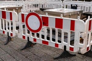Red and white barriers restrict access to a construction site in an photo