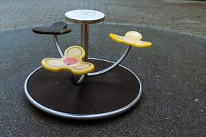 A colorful playground spinner designed for young children is situated photo