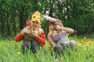 Two children hunt for Easter eggs in a spring garden. Easter tradition photo