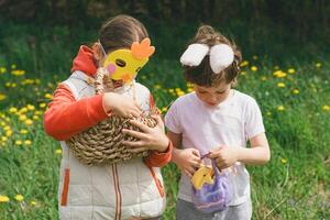 Two children hunt for Easter eggs in a spring garden. Easter tradition photo