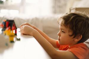 Cute boy is playing constructor at home. Kid playing block toys in home at nursery. photo