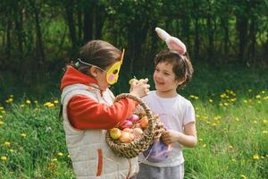 Two children hunt for Easter eggs in a spring garden. Easter tradition photo