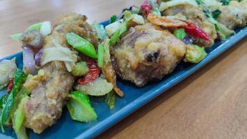 Fried chicken with salted egg in blue ceramic plate isolated with white. Selective focus. photo