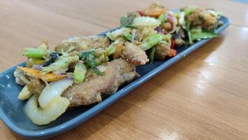 Fried chicken with salted egg in blue ceramic plate isolated with white. Selective focus. photo
