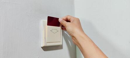inserting a card key into a switch in a modern hotel room during the day photo