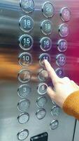 finger presses the number on the elevator button photo
