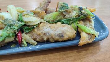 Fried chicken with salted egg in blue ceramic plate isolated with white. Selective focus. photo