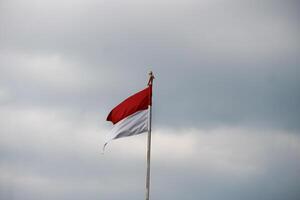 Indonesian flag fluttering in the wind with dark clouds in the background. photo