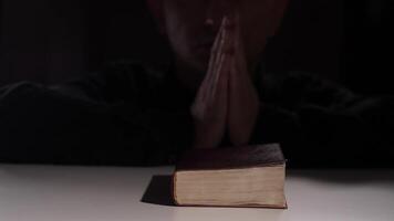 Priest praying with hands joined in front of holy book on white table video