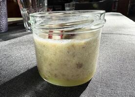 Fermented sourdough starter jar on textured gray fabric in sunlight photo