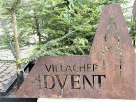 Villacher advent rustic sign with evergreen trees in winter decoration photo