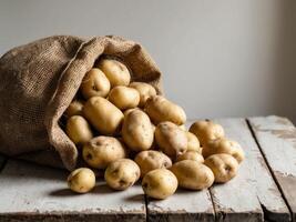 Potatoes in a sack on a wooden table photo