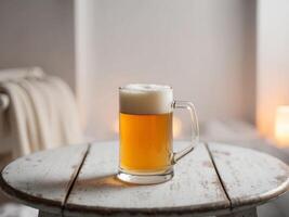 A glass of beer on a table in front of a candle photo