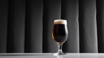 A glass of dark beer sitting on a table photo