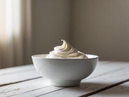 A bowl of whipped cream on a wooden table photo