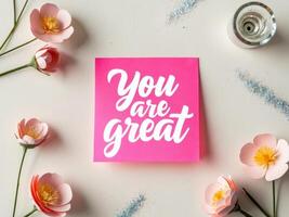 You are great note paper with flowers and pink paper flowers on white background photo