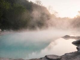 A hot spring with steam rising from the water photo