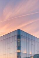 A building with a large glass facade at sunset photo