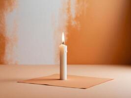 A single candle on a piece of paper on a table photo