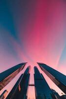 Tall buildings with pink sky and clouds in the background photo
