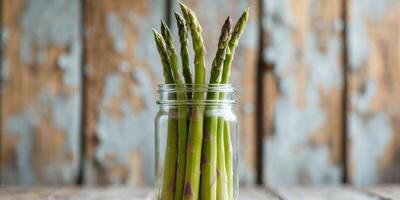 Preserved green asparagus in jar with selective focus on rustic wooden background showcasing healthy food preservation techniques photo
