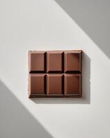 a chocolate bar with six square pieces showcasing a smooth glossy surface photo