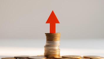A red arrow pointing up from a pile of coins photo