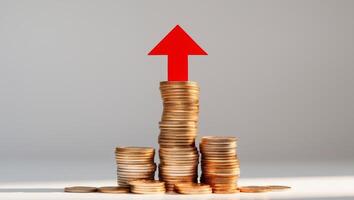 a stack of coins with a red arrow pointing up photo