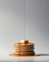 A stack of pancakes with syrup being poured over them photo
