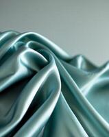 a close up view of flowing teal satin fabric showcasing its smooth texture and sheen photo